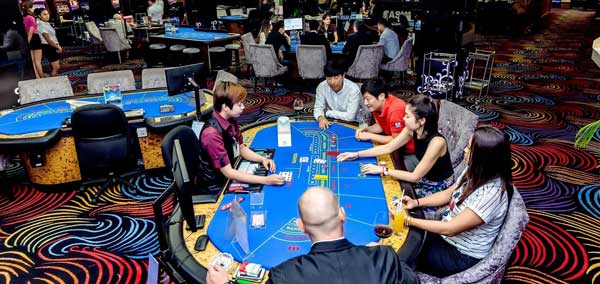 Players at a Baccarat Table inside the Queenco Casino